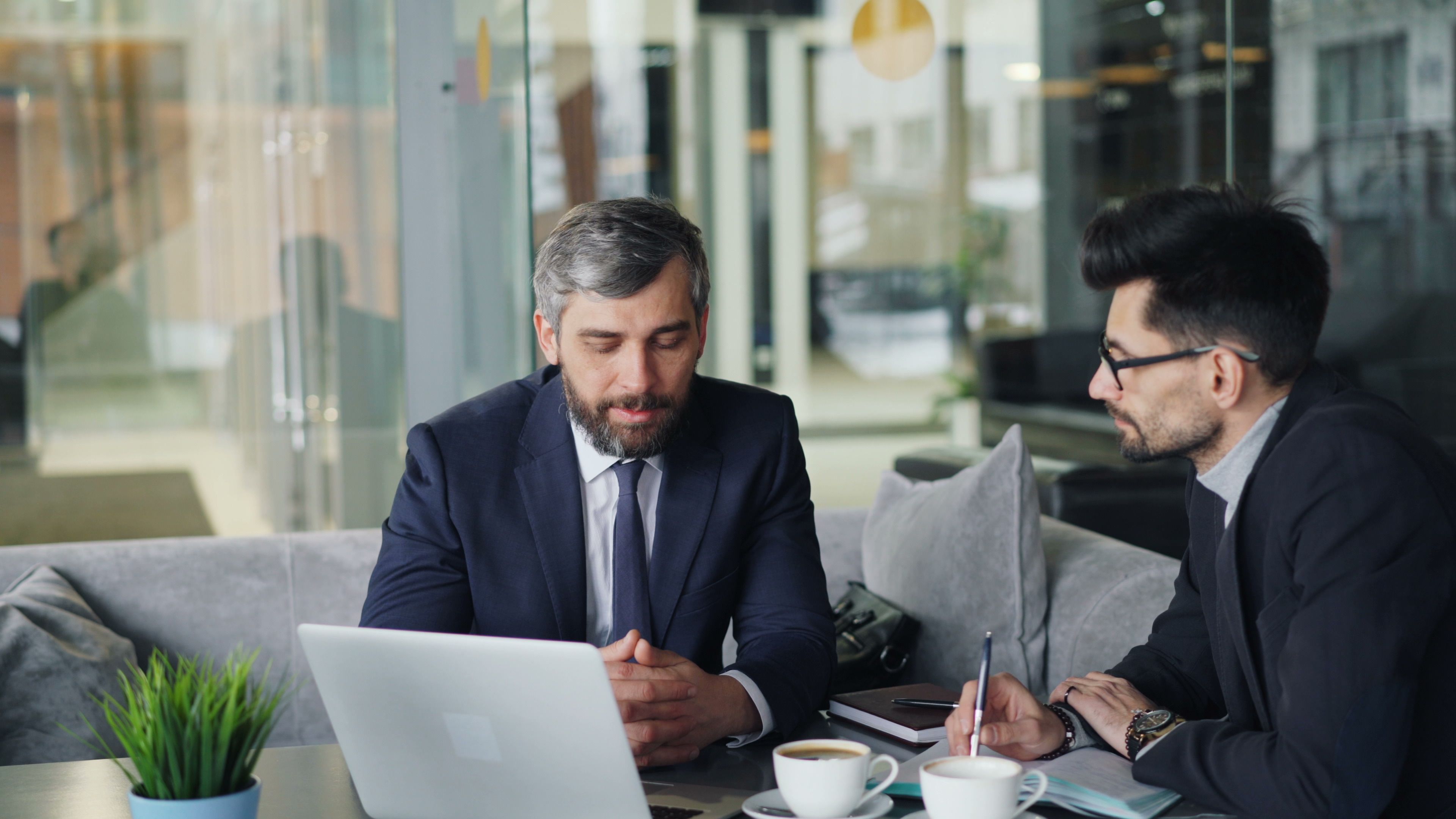 Senior consultant advising a client in a modern office